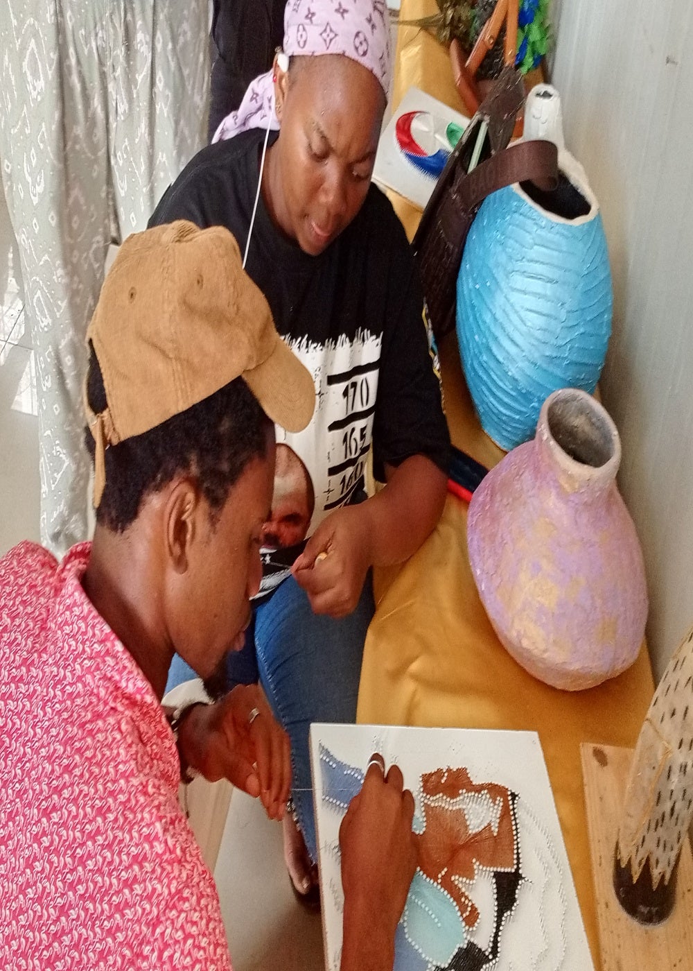 2 Jóvenes de la ONG fabricando objetos con material reciclado